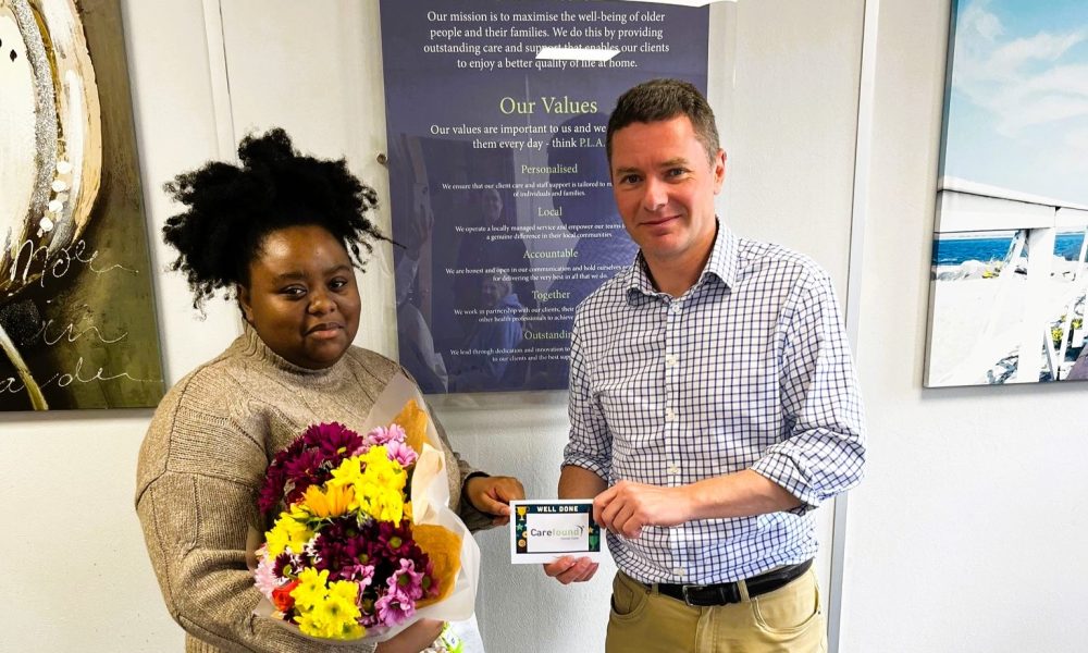 Live-in carer receiving her gift vouchers and flowers from Carefound Home Care
