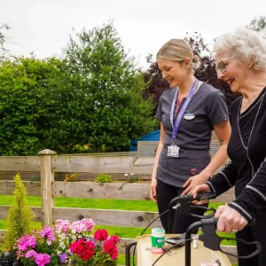 carer-with-elderly-lady-in-garden-scaled-e1725908604591