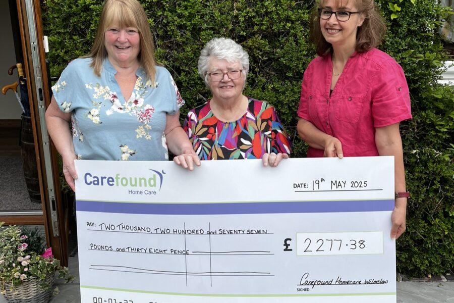 Care professionals and client holding cheque for the MND Assocaition
