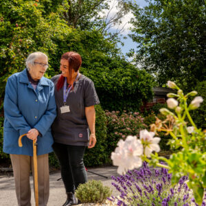 Care professional with elderly lady in sunshine